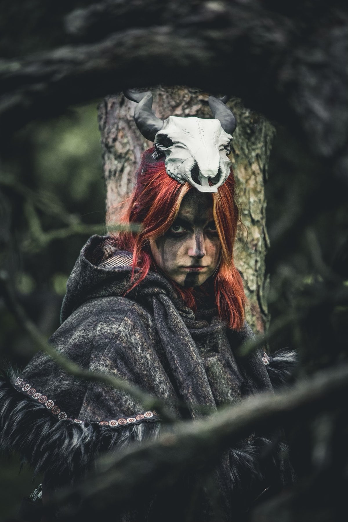 Medieval LARP outfit with a grey hooded tunic, fur trim, and skull headdress.