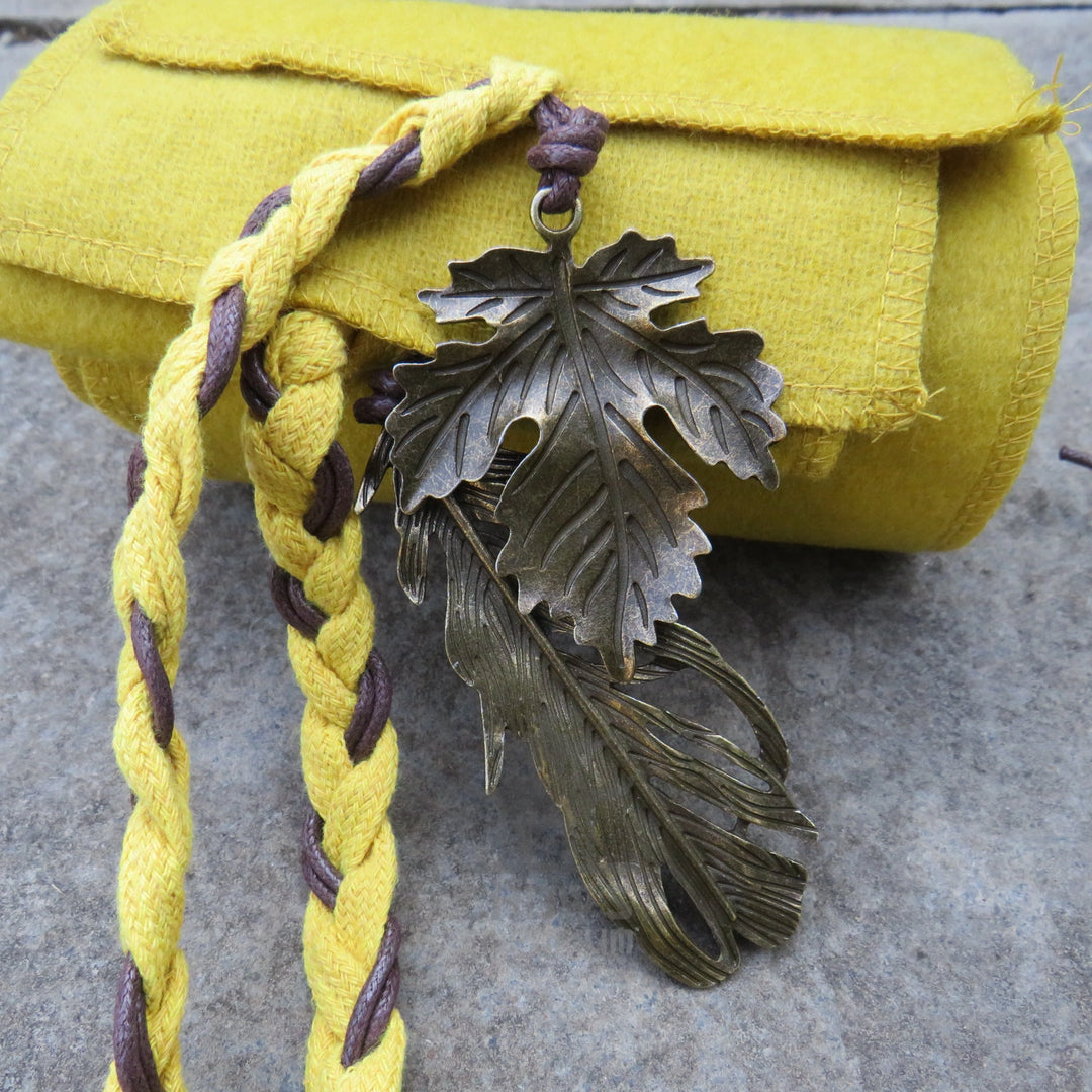 Leather-look cord and metal charm on the end of the ochre sash