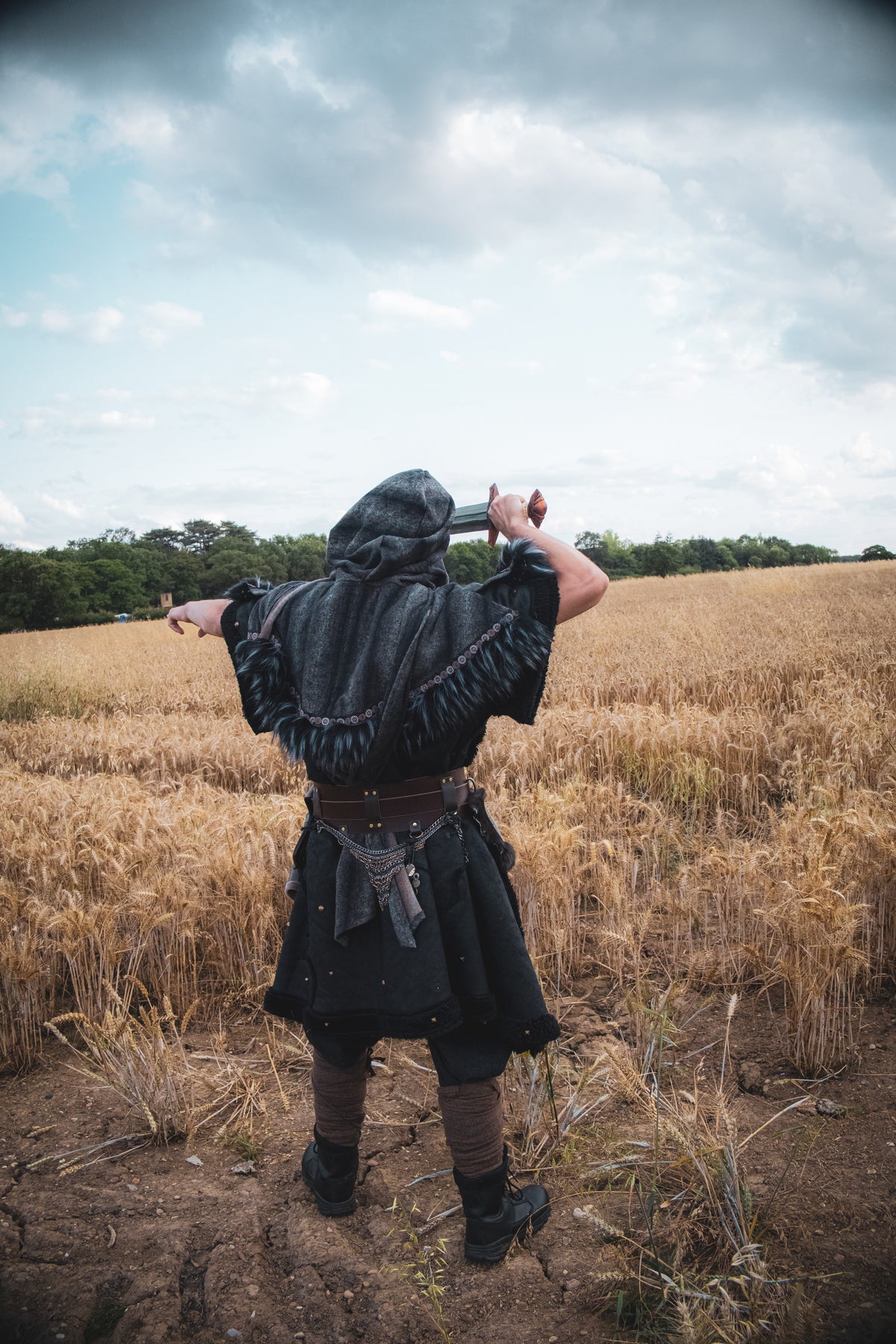 Medieval LARP costume back view featuring a black faux leather tunic and wool wrap around hood.