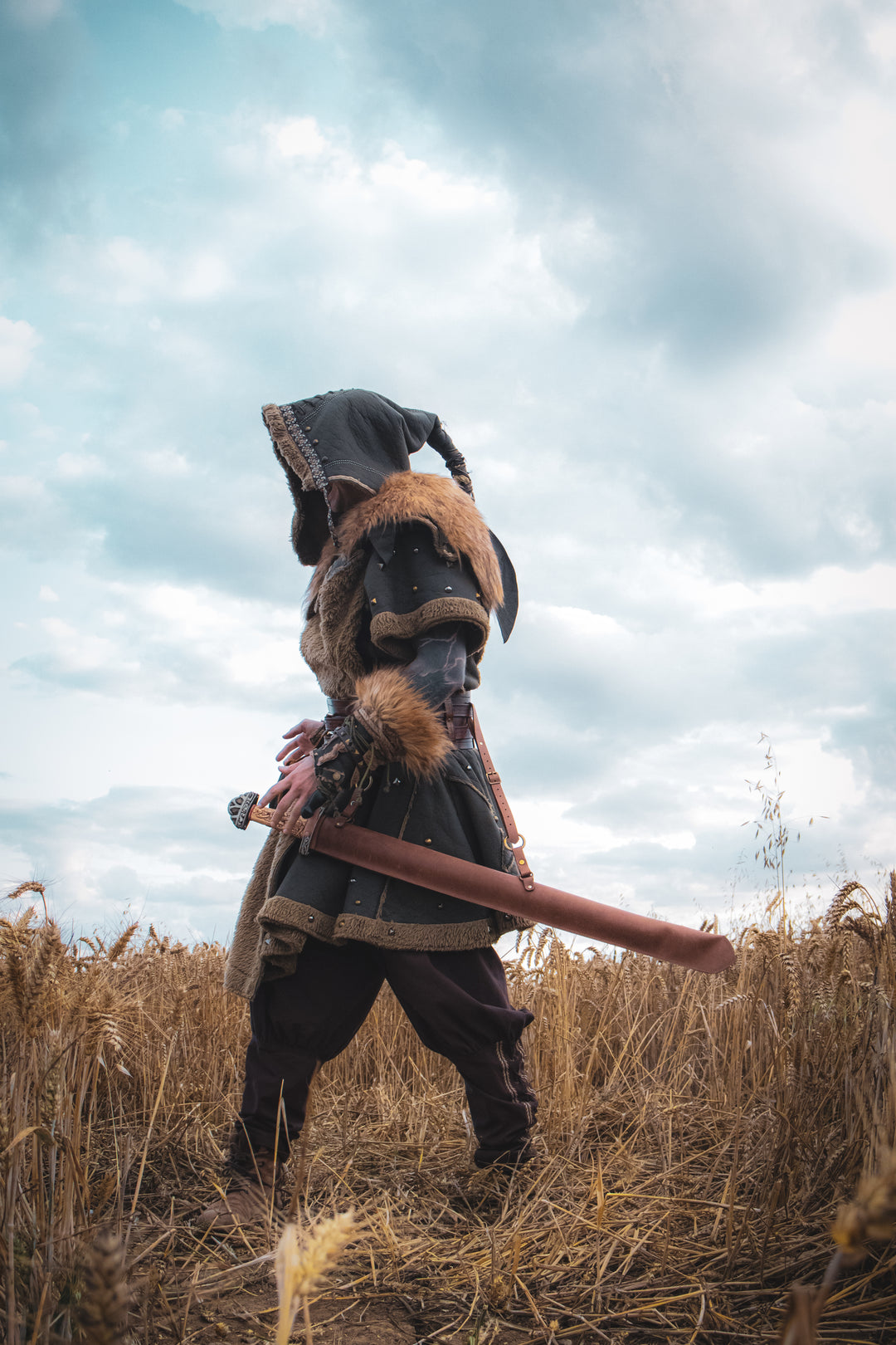 Barbarian LARP set with tunic, hood, and vambraces in a wheat field.