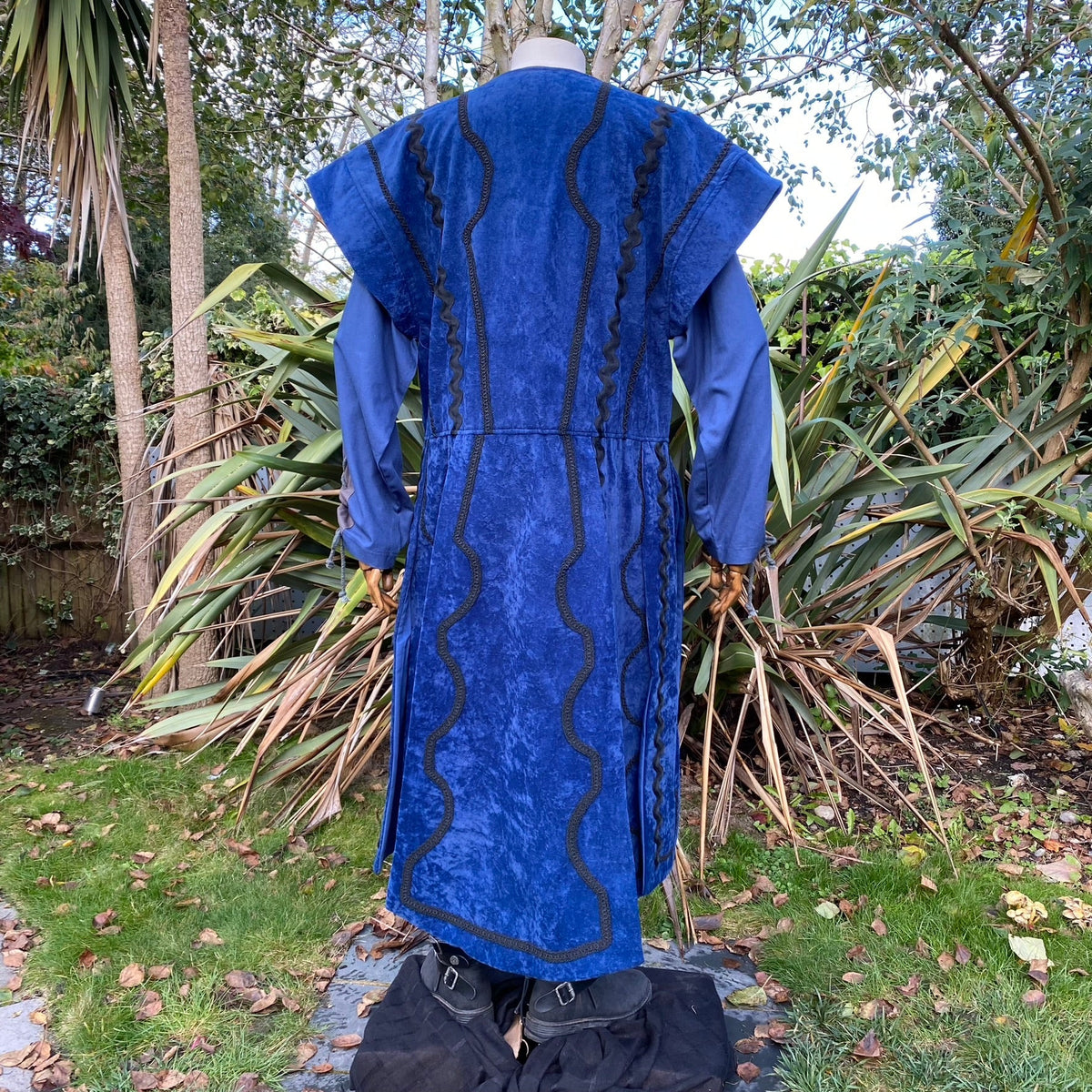 Back view of blue medieval LARP waistcoat with wavy black trim.