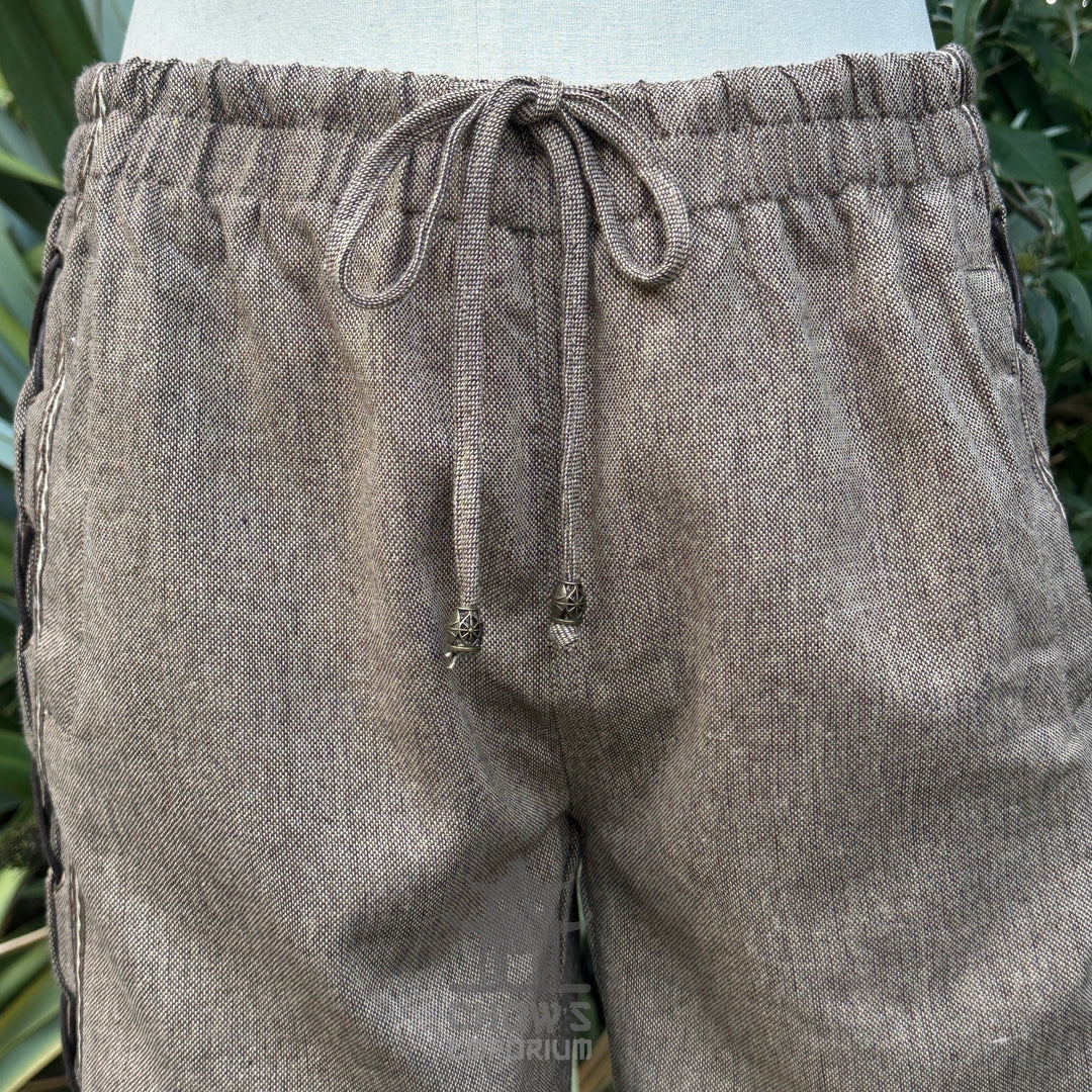 close-up of brown wool medieval trousers lace and braid trim.
