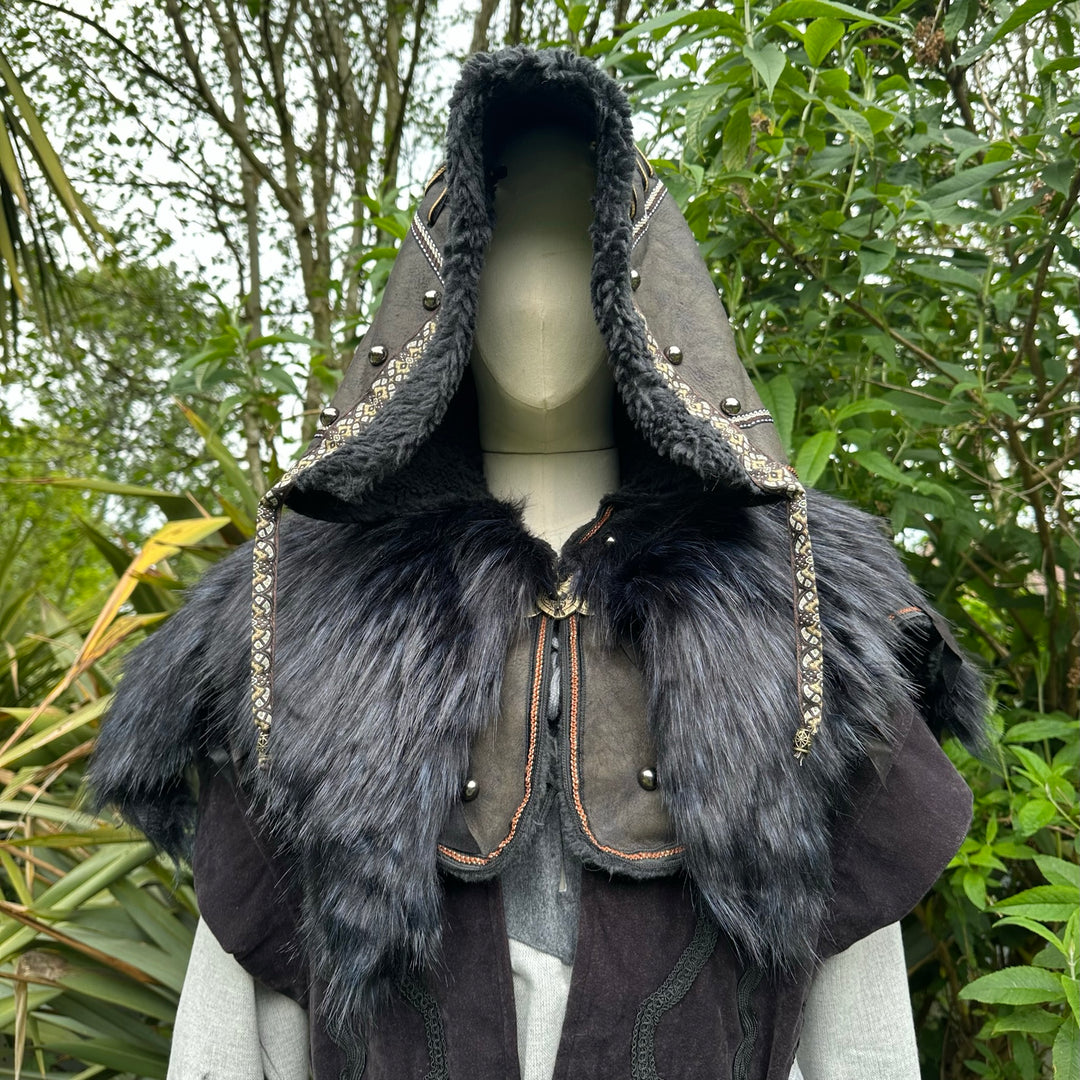 Medieval LARP outfit close-up: hood and fur, nature backdrop.