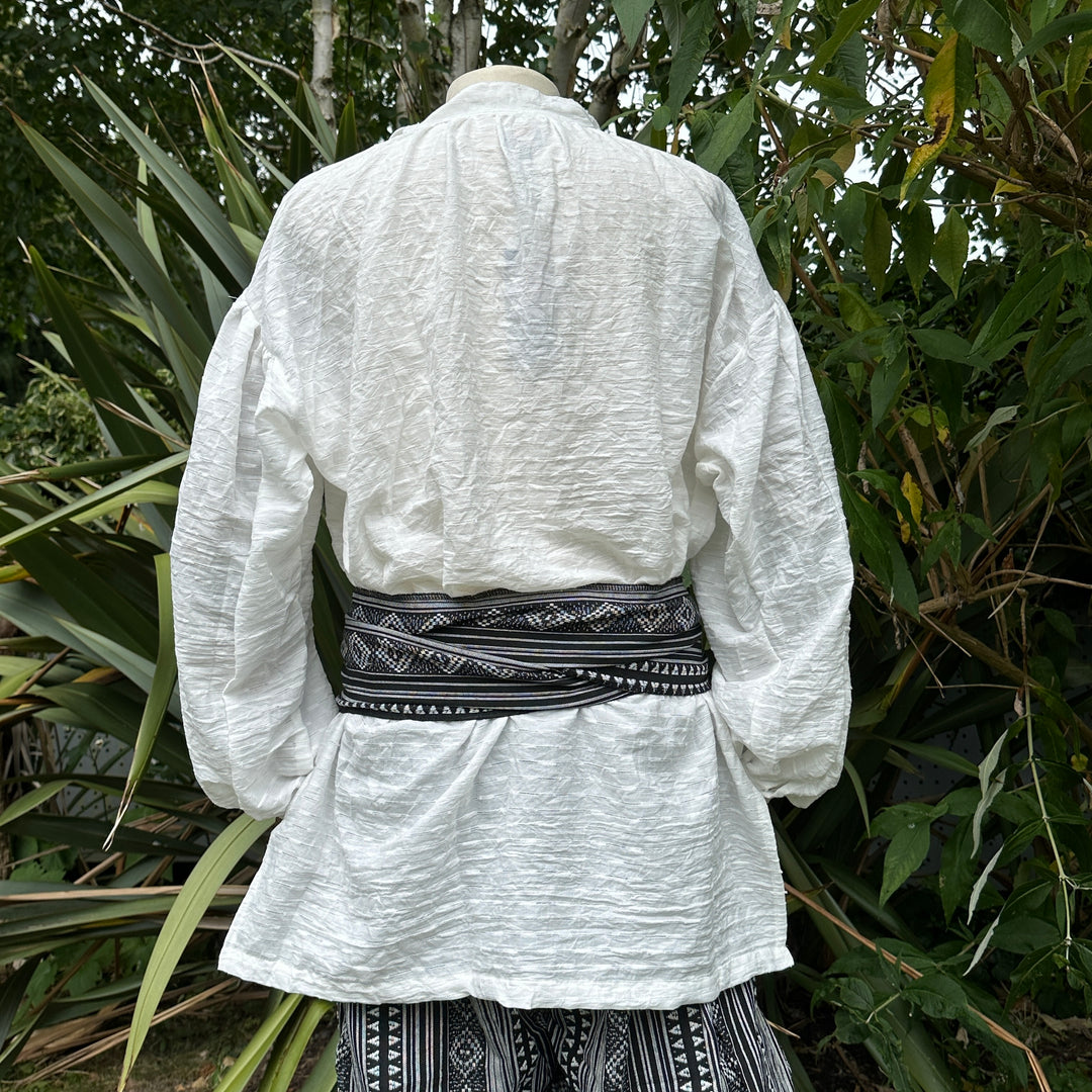 Medieval LARP outfit back view, featuring black and white patterned trousers and matching sash.
