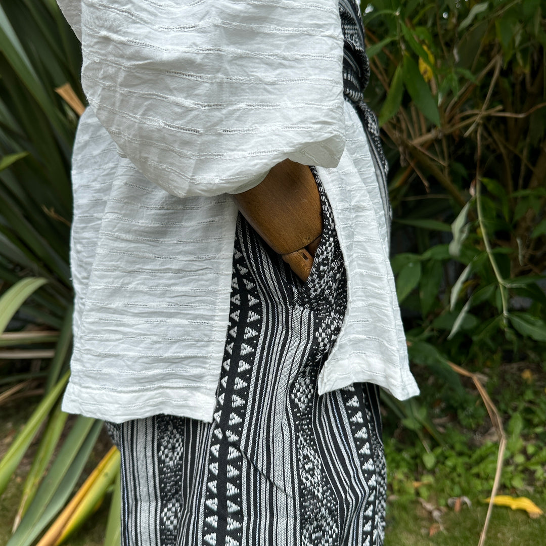 White medieval shirt and black patterned LARP pants from side view.