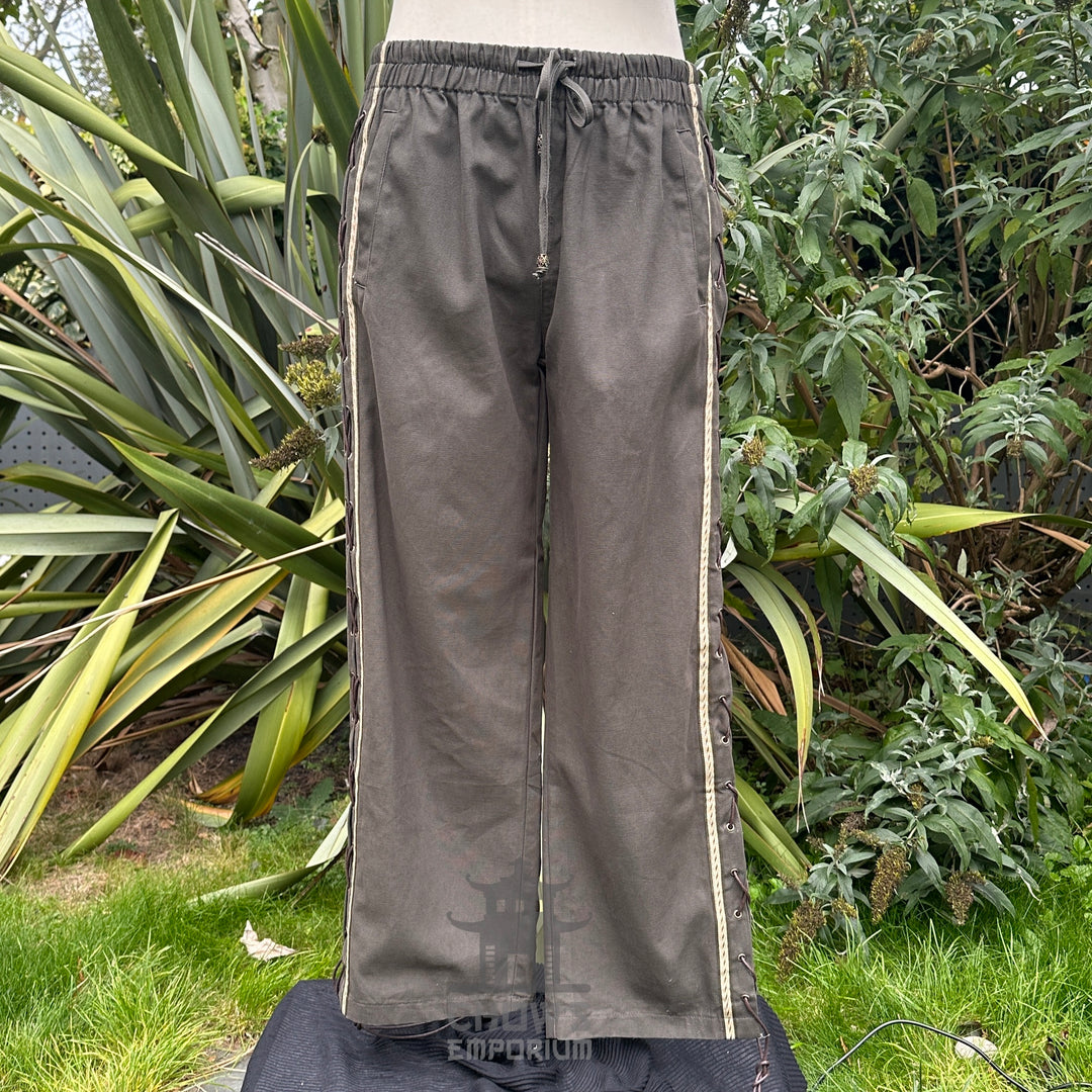 Medieval LARP pants in garden setting with side lace visible.