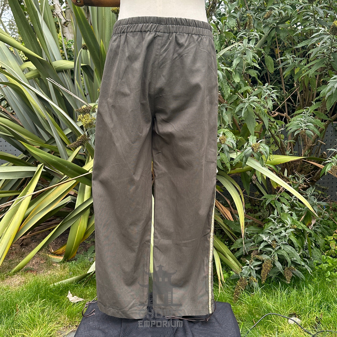 Back view of medieval straight-leg trousers in grey cotton with relaxed unisex fit no boots.