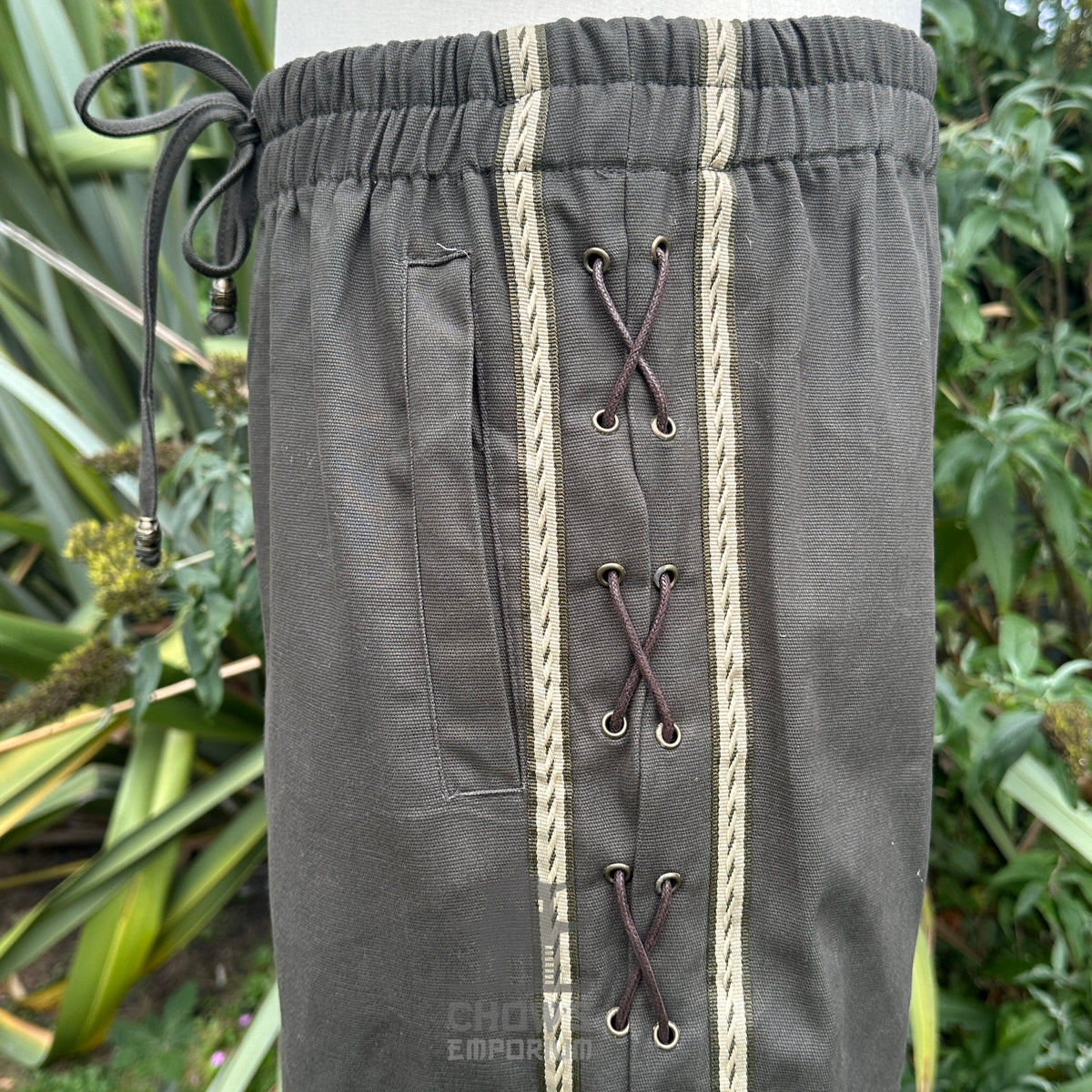 Close-up of braided trim and reinforced stitching on side seam of medieval trousers.