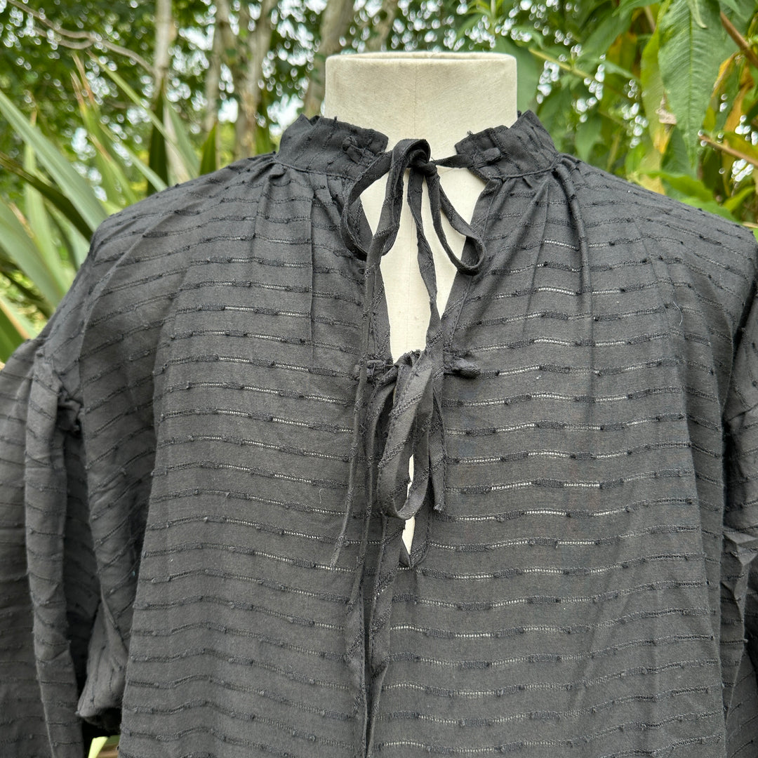 close up of textured fabric on black medieval shirt.