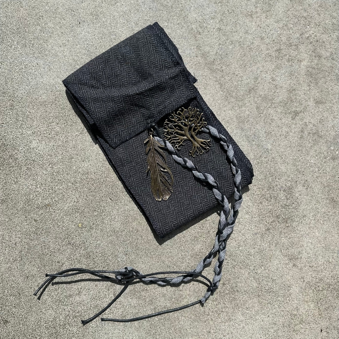 Braided sash with metal leaf and tree charms on grey for LARP medieval attire.