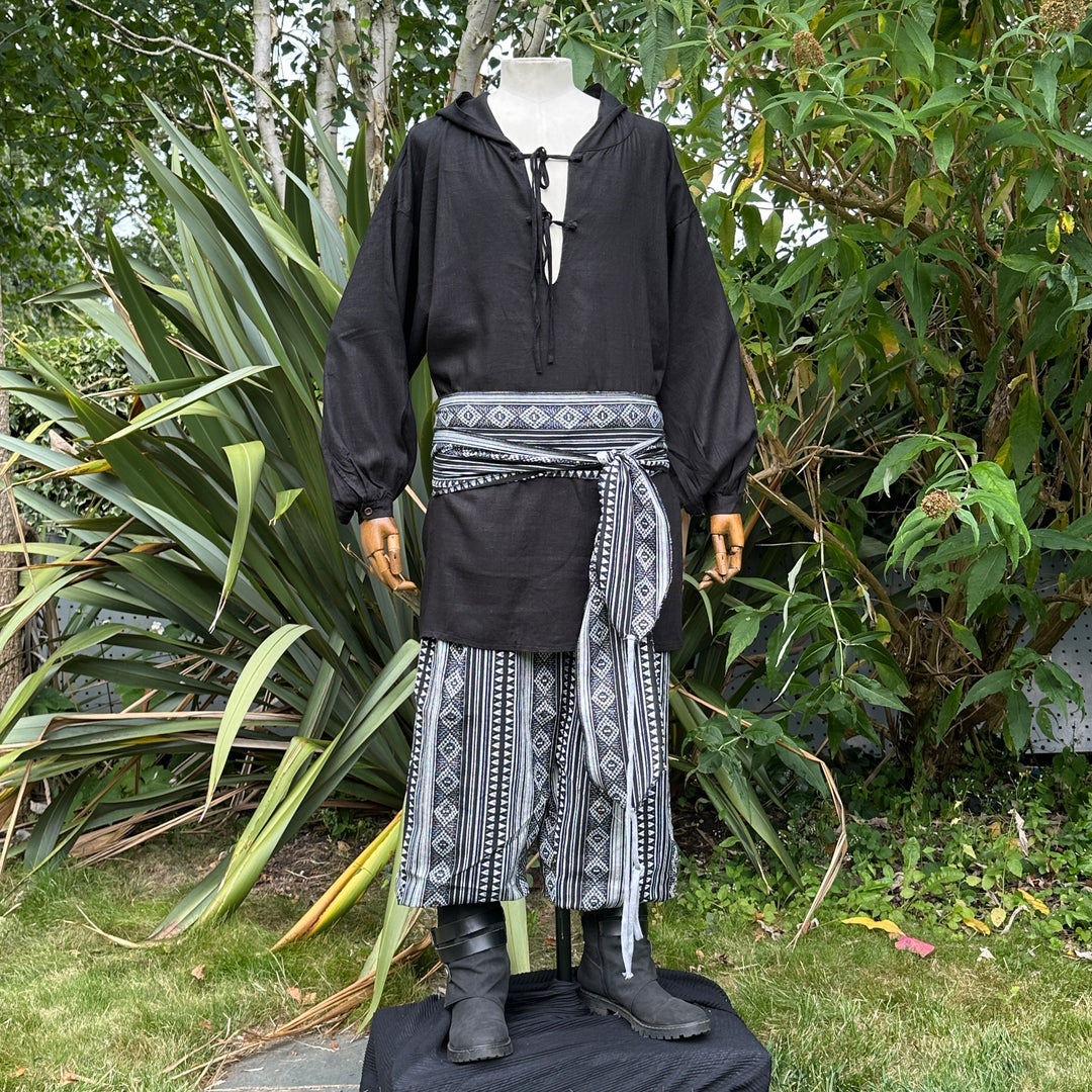 Black hooded shirt, patterned pants, and sash, medieval LARP style outfit.