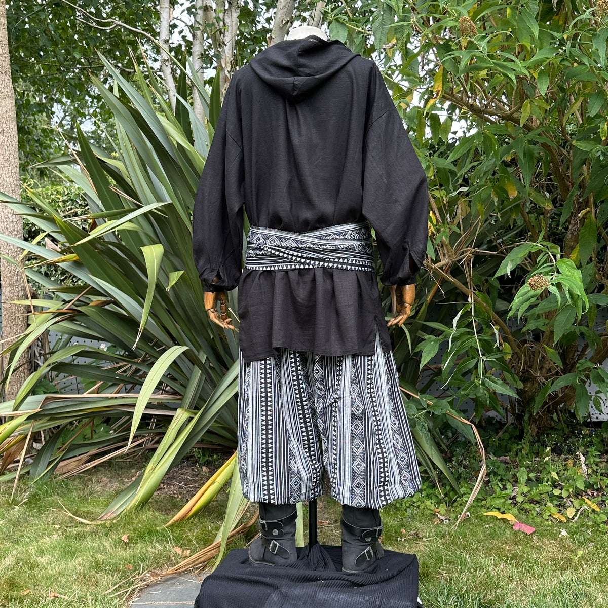 LARP black hooded shirt and patterned pants with sash, back view.