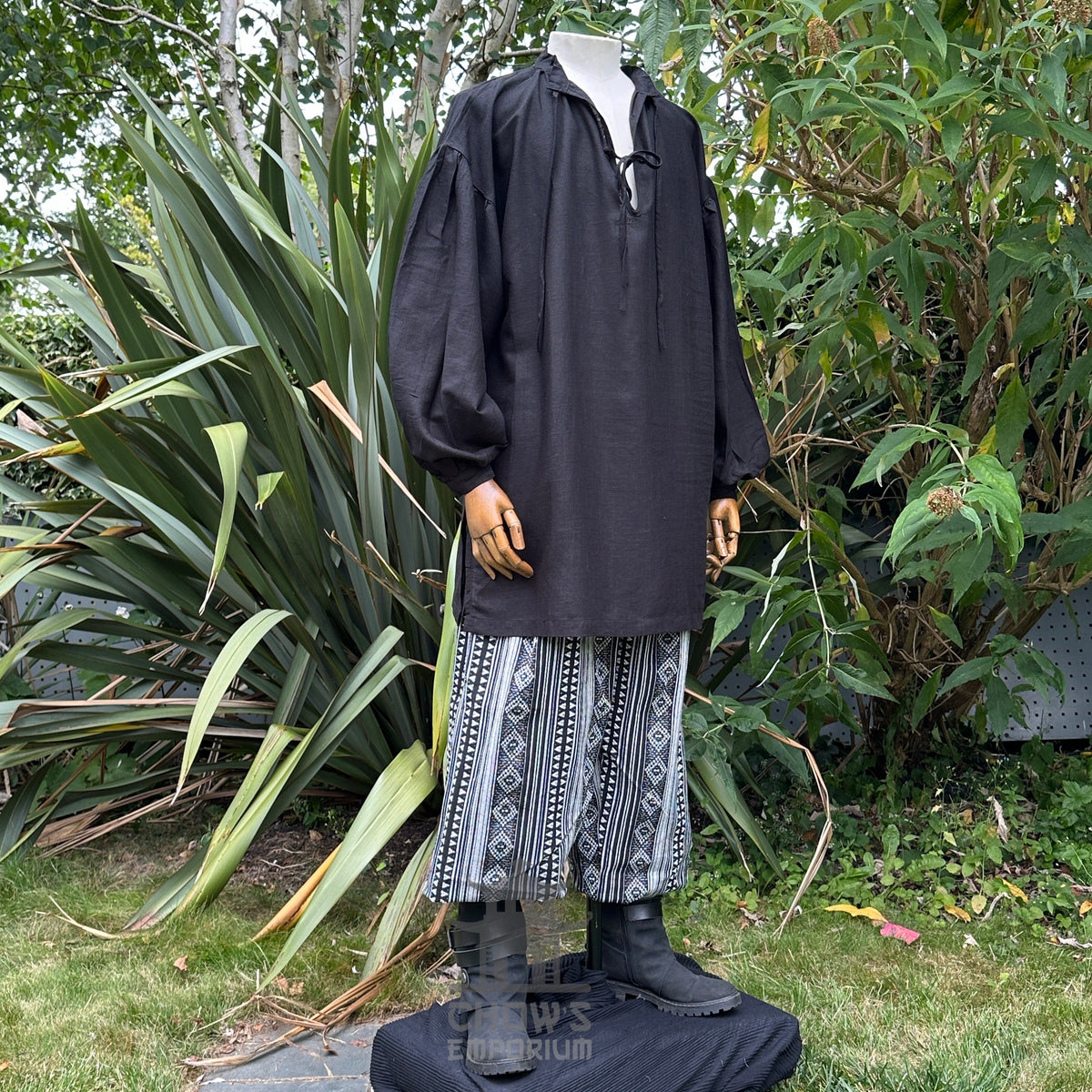 Black medieval LARP tunic with patterned pants, front view.