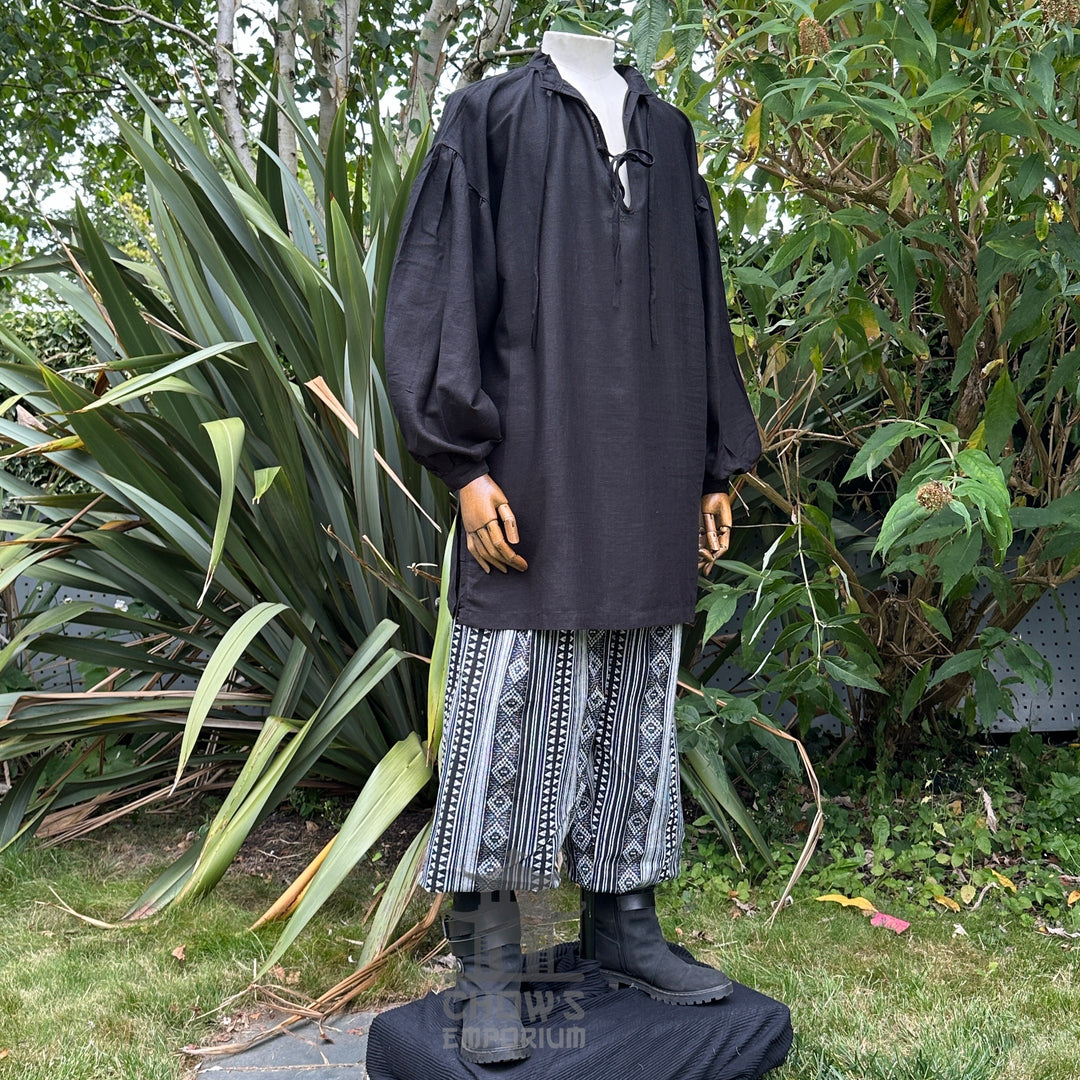 Black medieval LARP tunic with patterned pants, front view.
