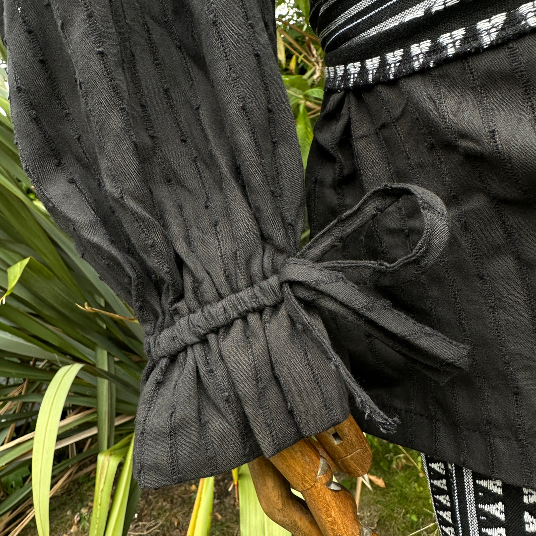 close up texture on black cotton medieval round-neck shirt.