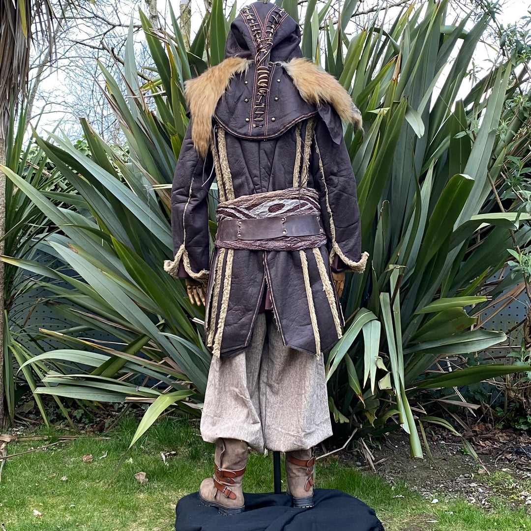 Medieval LARP costume back view featuring a brown faux leather jacket, hood and vambraces, shirt.