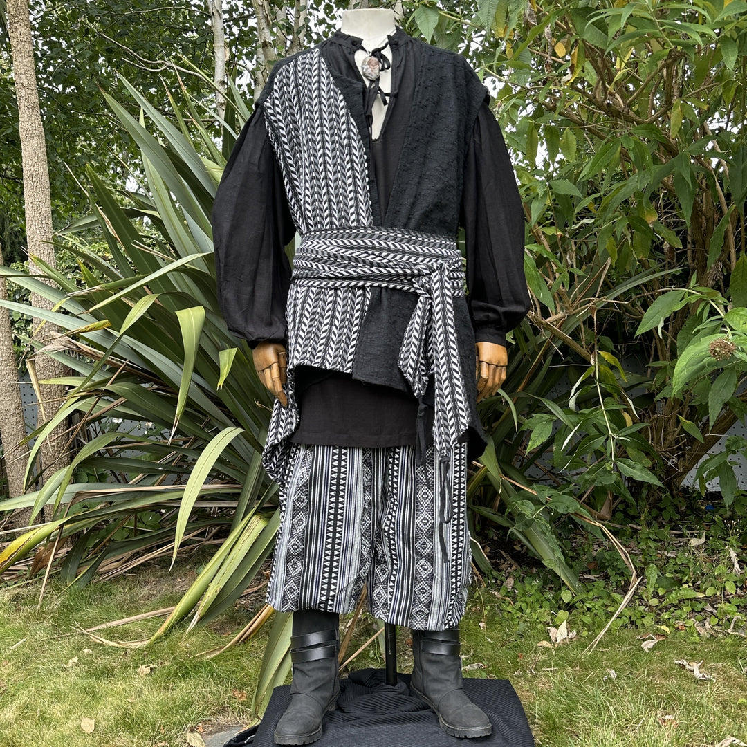 Medieval LARP outfit side view, patterned wrap and black boots.