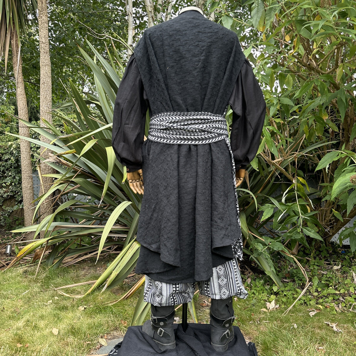 Back view of LARP outfit with patterned belt and layered black cloak.