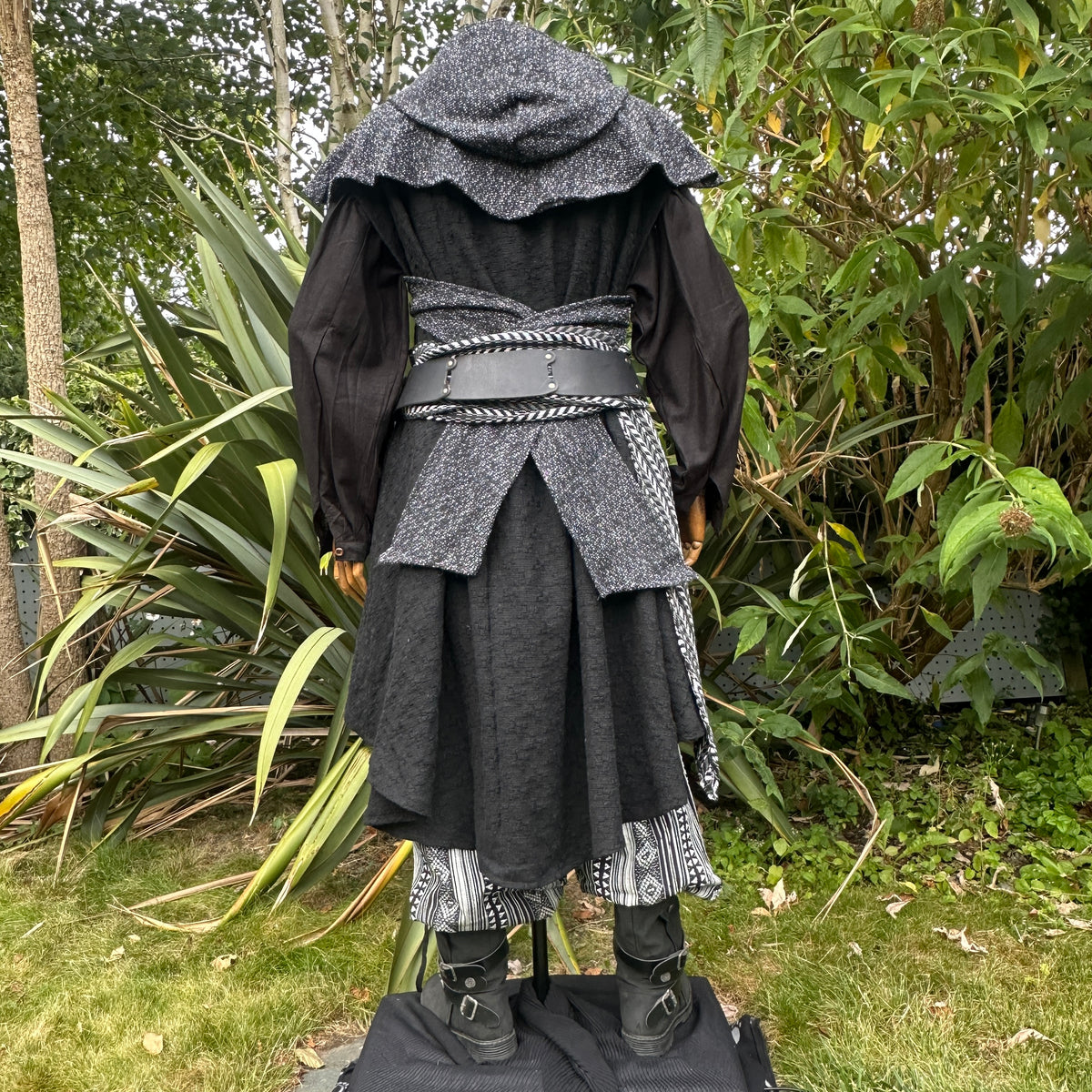 Back view of medieval LARP ranger costume with hood and layered skirt.