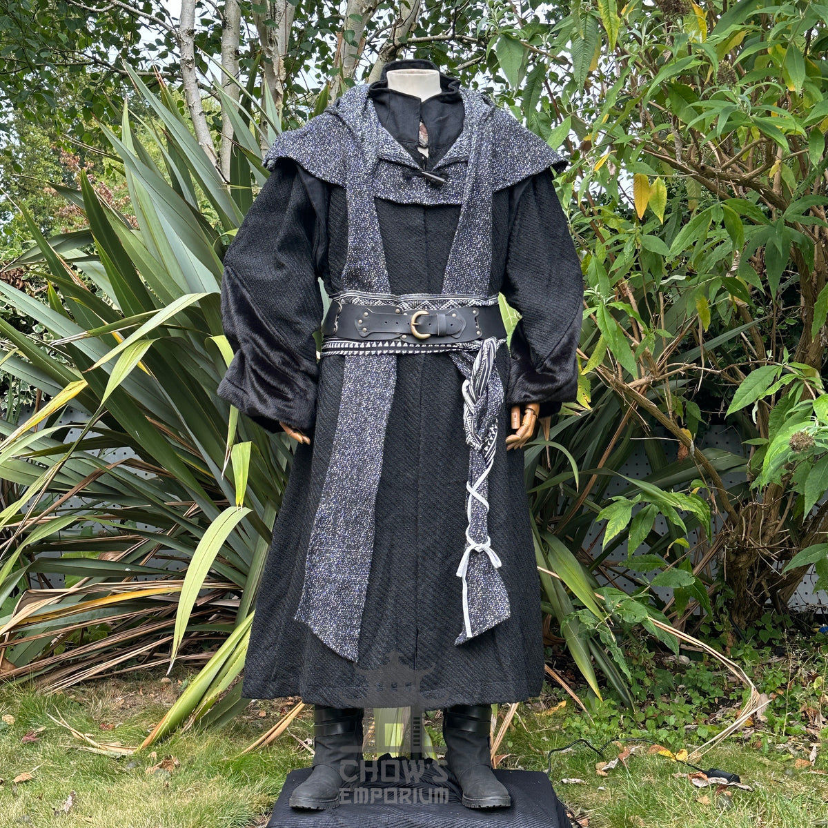 Black LARP robe with ornate hood, scarf, and belt, surrounded by greenery.