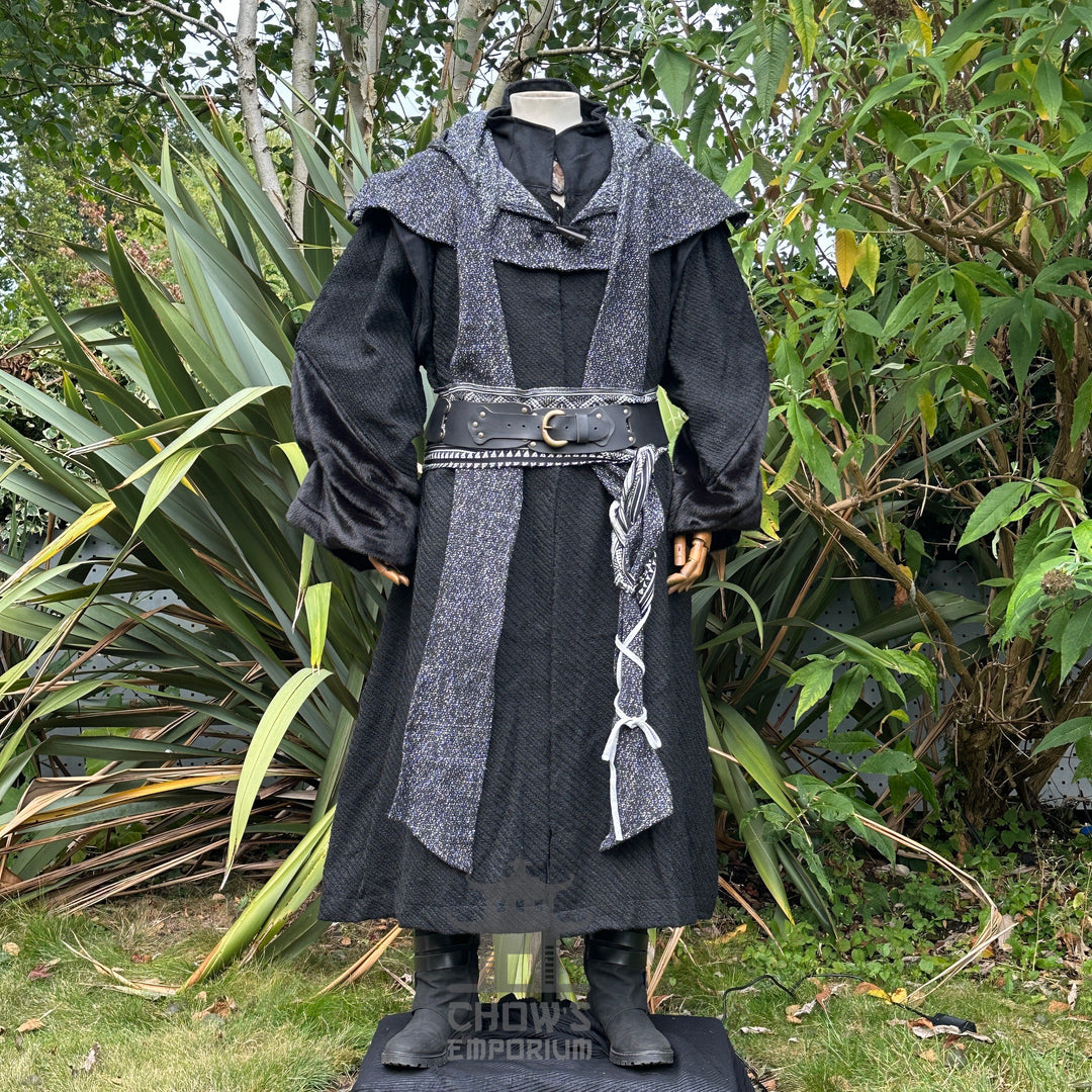 Black LARP robe with ornate hood, scarf, and belt, surrounded by greenery.