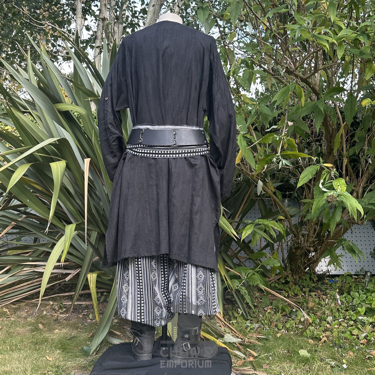 Medieval LARP outfit back view, featuring a black tunic, patterned trousers and sash.