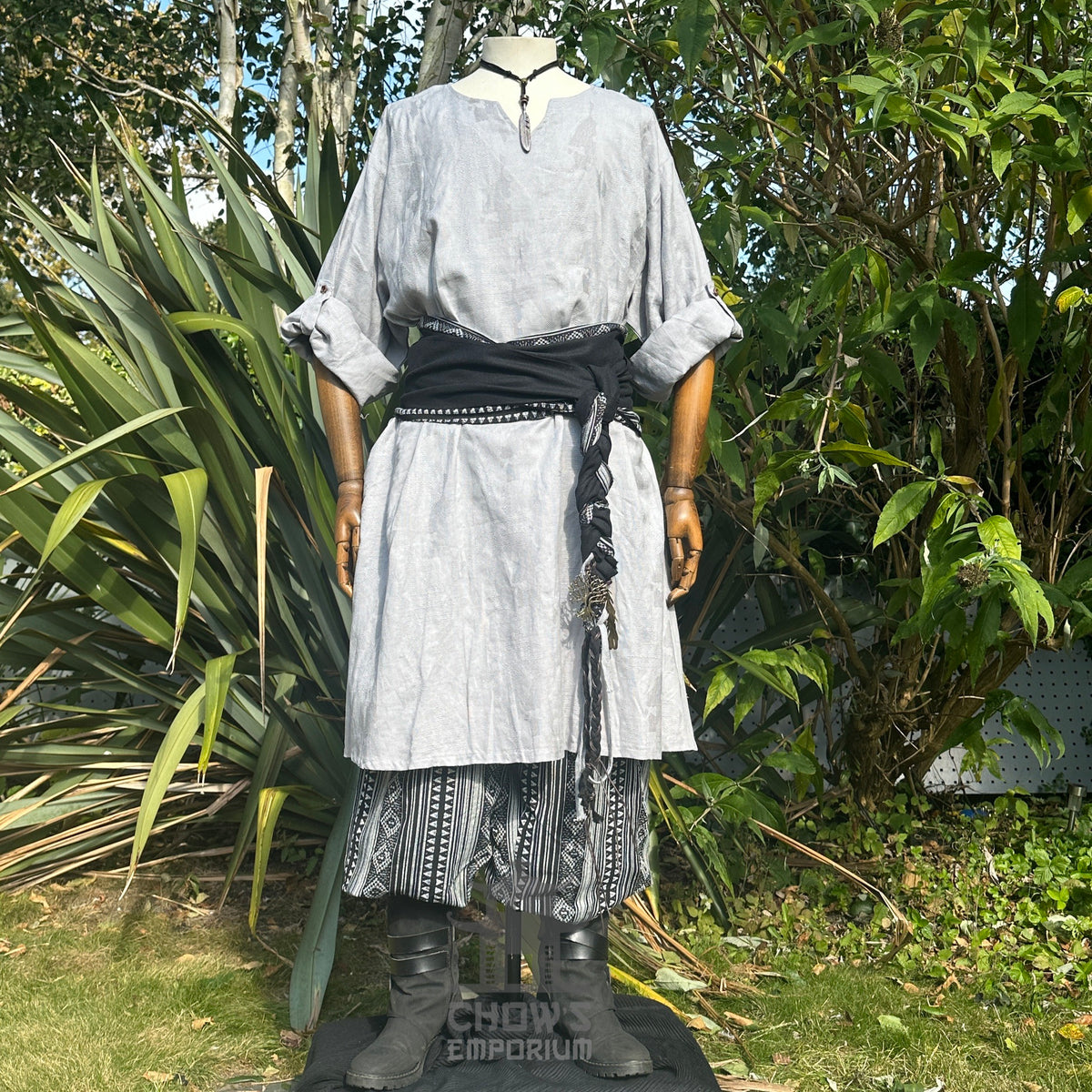 LARP basic outfit in light grey tunic, patterned trousers, black sash.
