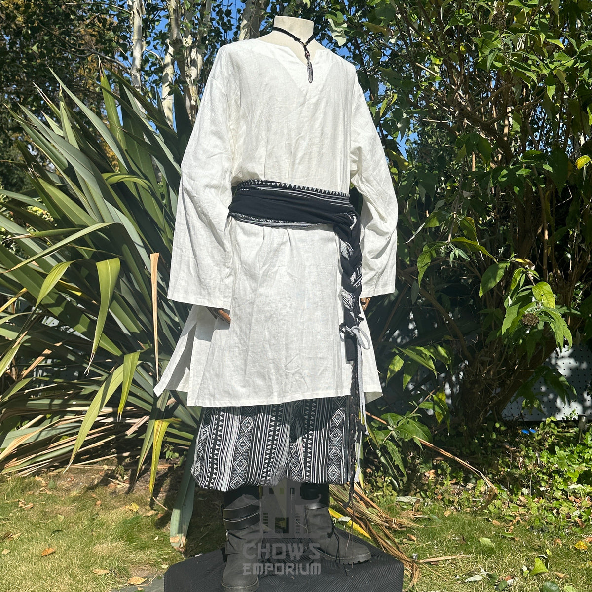 LARP medieval outfit with white tunic, black belt and sashes, side view.