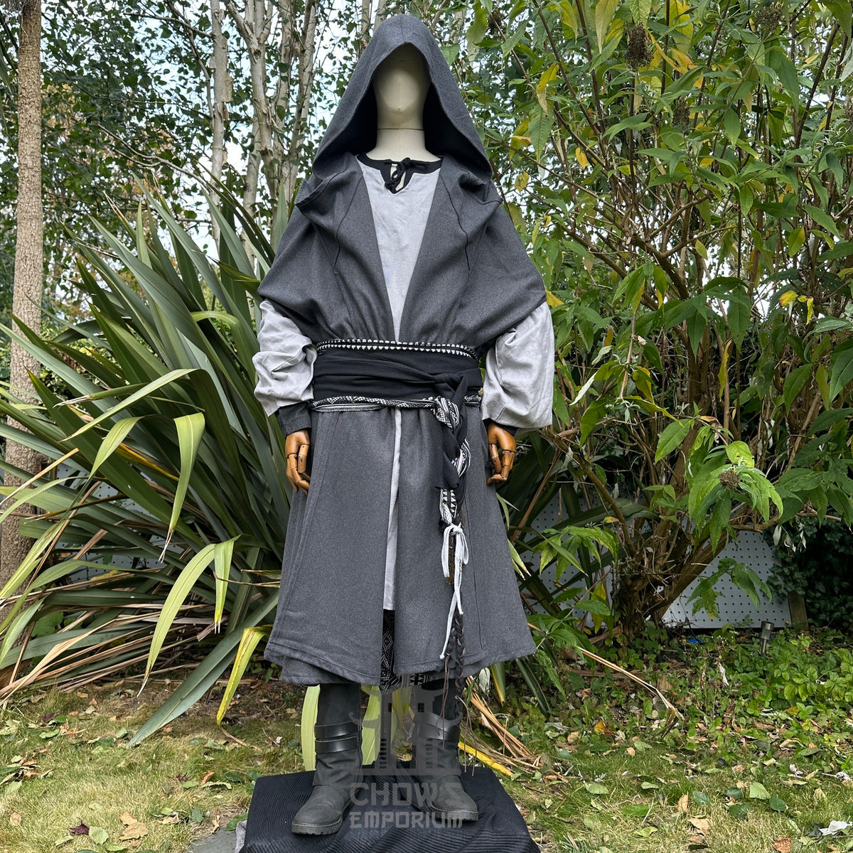 Cloaked medieval LARP outfit with wide hood, garden backdrop, frontal view.