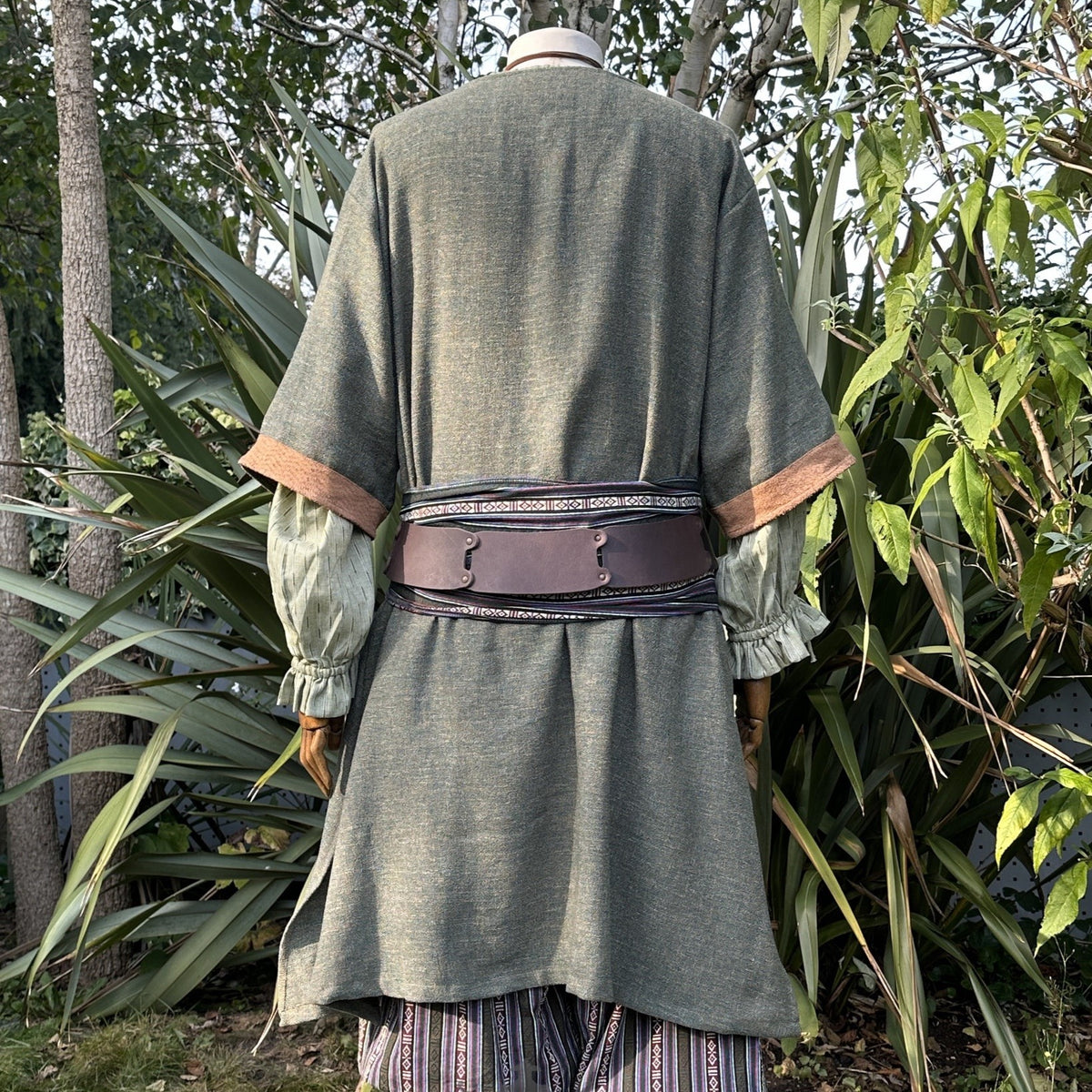 Green medieval LARP tunic, back view, with brown sash and detailed sleeves.