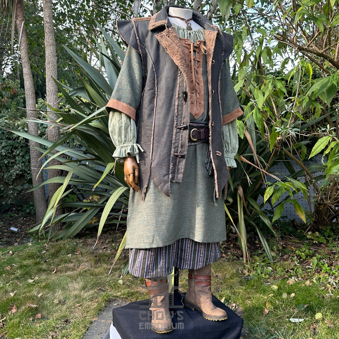 Medieval LARP outfit side view, featuring a green faux leather waistcoat, tunic, trousers and sash.