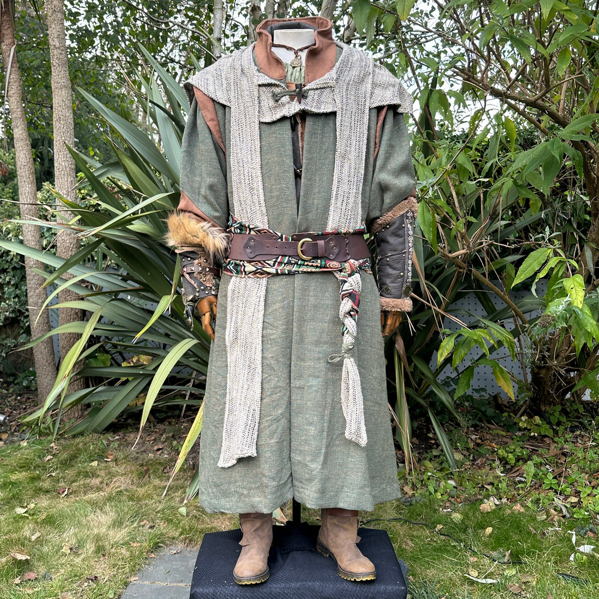 Medieval LARP costume front view featuring green robe, wool hood, vambraces, belt, sash and.