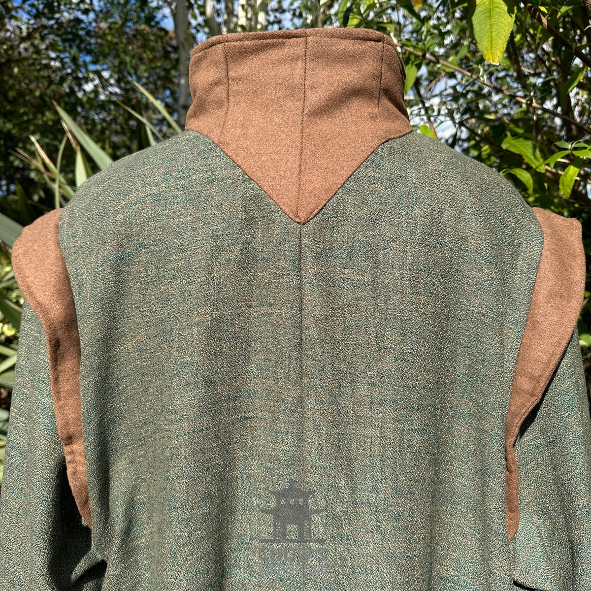Close-up of fabric texture and shoulder seam on green and brown high-collar LARP robe, medieval.