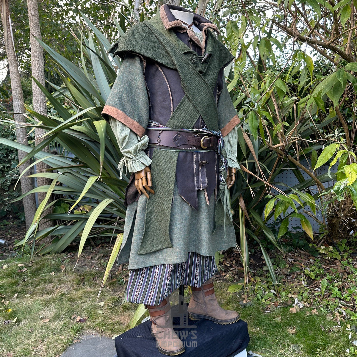 Medieval LARP costume side view, featuring a brown leather waistcoat, green tunic, shirt, hood.