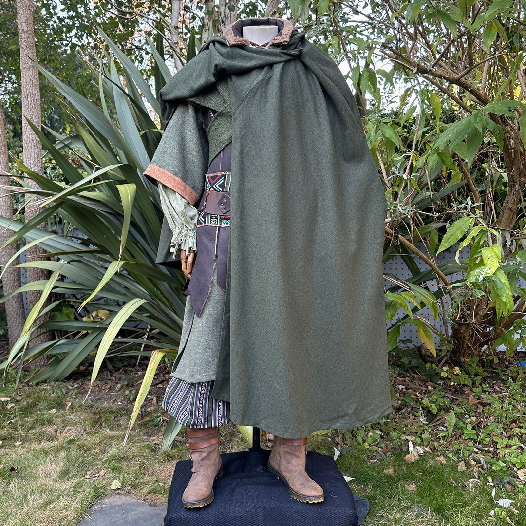 Green wool cloak over medieval LARP costume, leather boots visible.