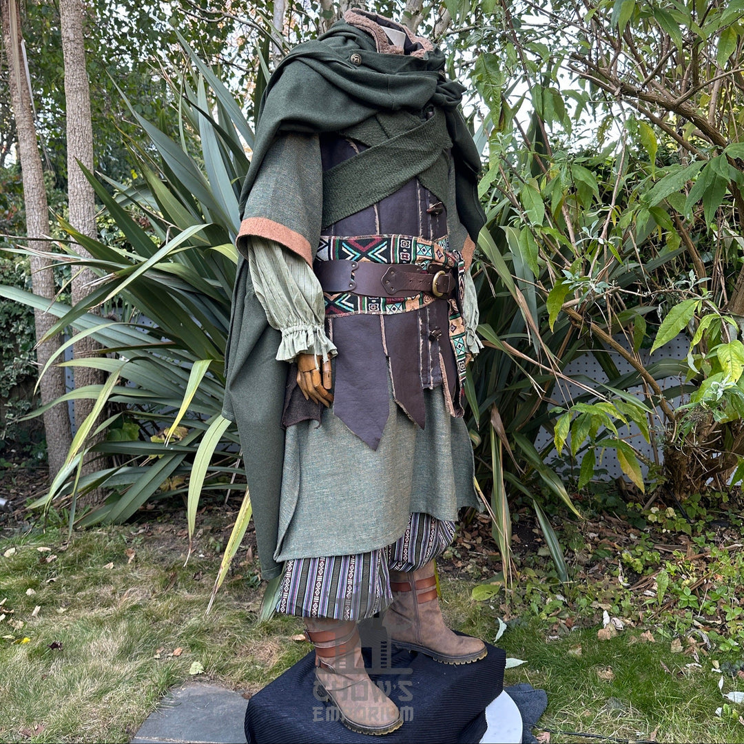Medieval LARP outfit side view, featuring a green cloak, waistcoat, hood, shirt, trousers, belt.