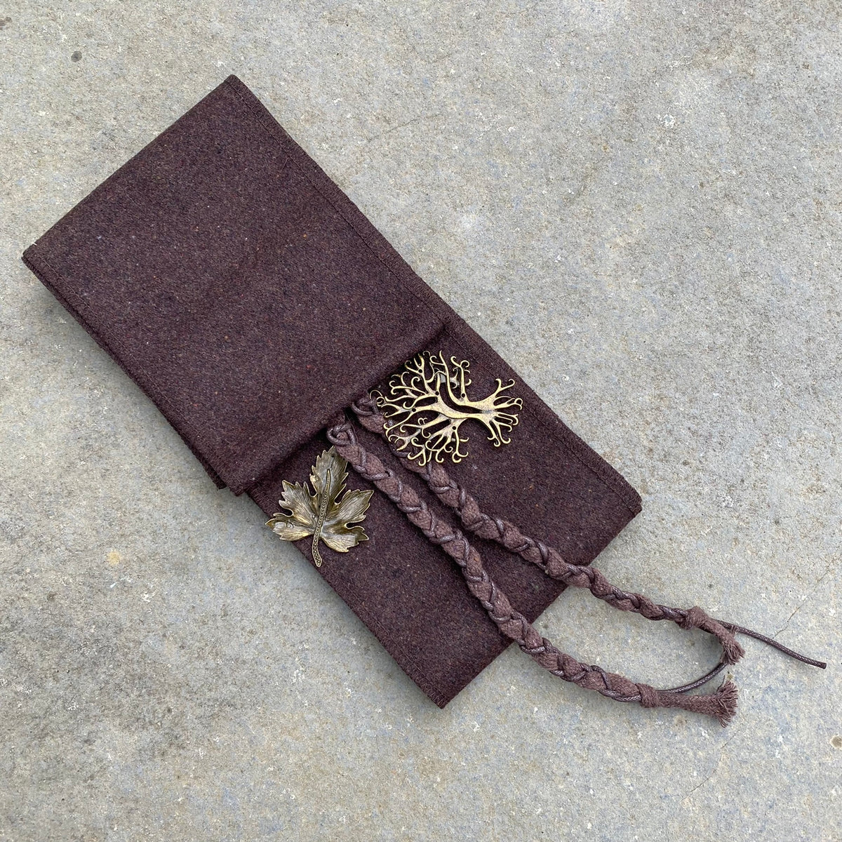Brown LARP belt and sash set with metallic leaf accents on stone surface.