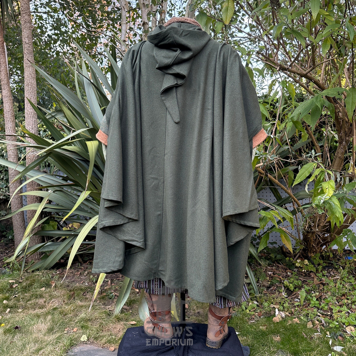 Cloaked forest ranger from behind, in a green medieval LARP setting.