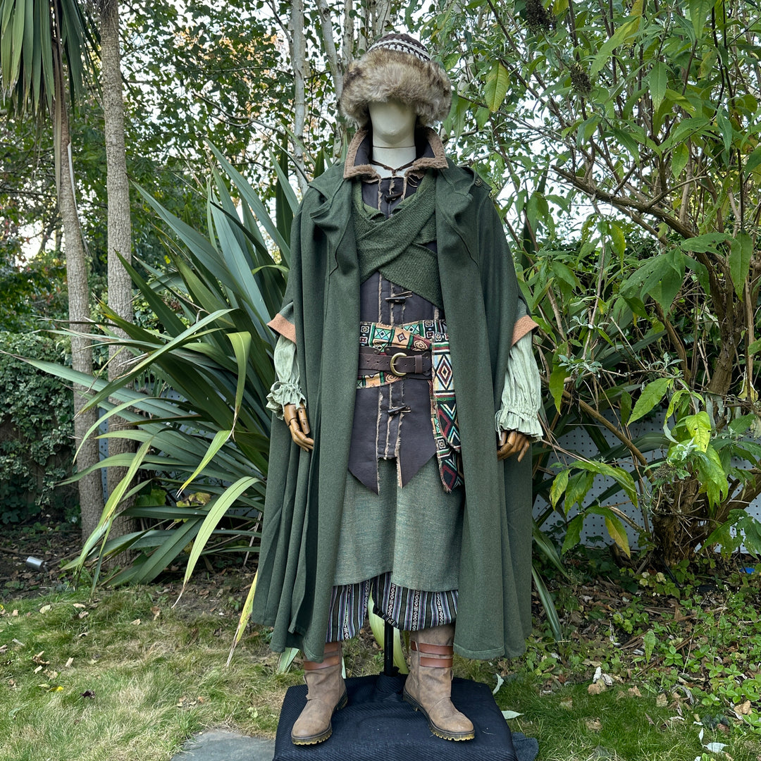 Mannequin in LARP medieval green cloak, garden setting, elaborate layered outfit.