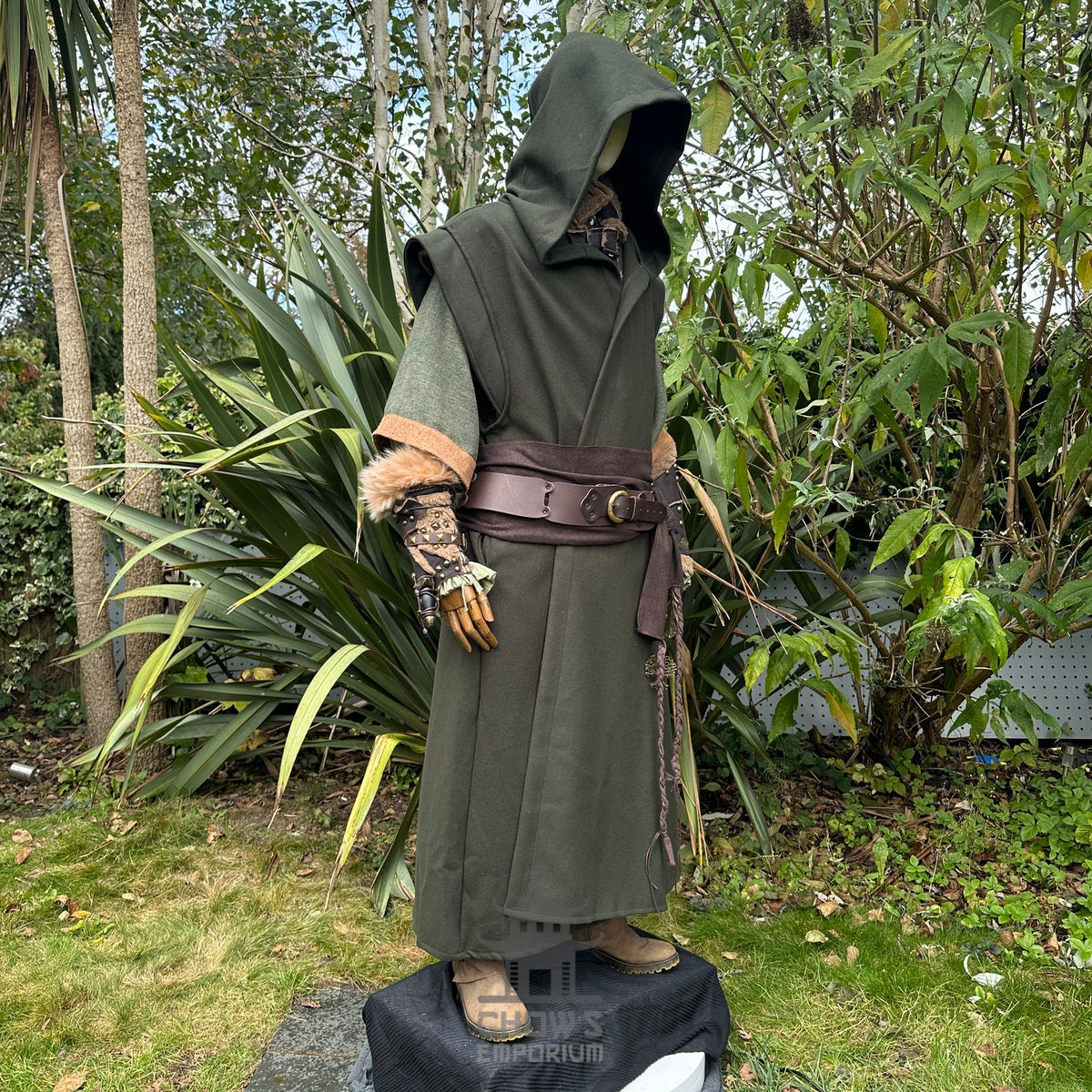 Medieval LARP outfit side view, featuring a green hooded robe, vambraces, belt, and sash.