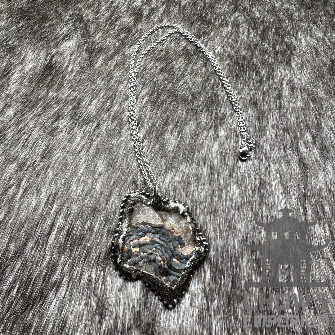 Silver necklace with geode pendant on a textured fur background, medieval LARP style.