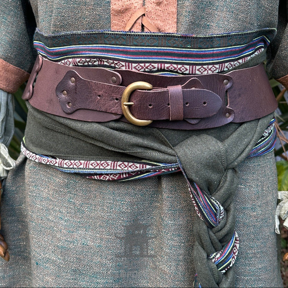 Medieval LARP outfit close-up, green-brown fabric, leather belt, intricate trims.