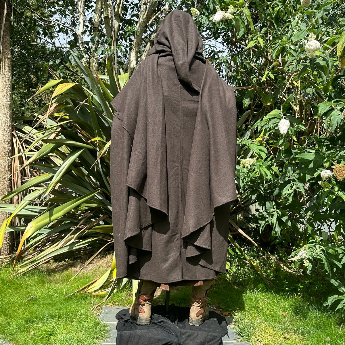 Medieval LARP costume back view featuring brown cloak, faux leather hood, arm wraps and sash.