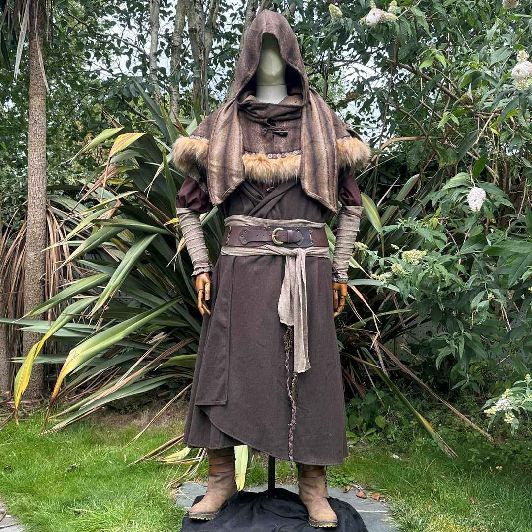 Forest alchemist costume with fur trim, displayed amidst lush greenery for LARP.