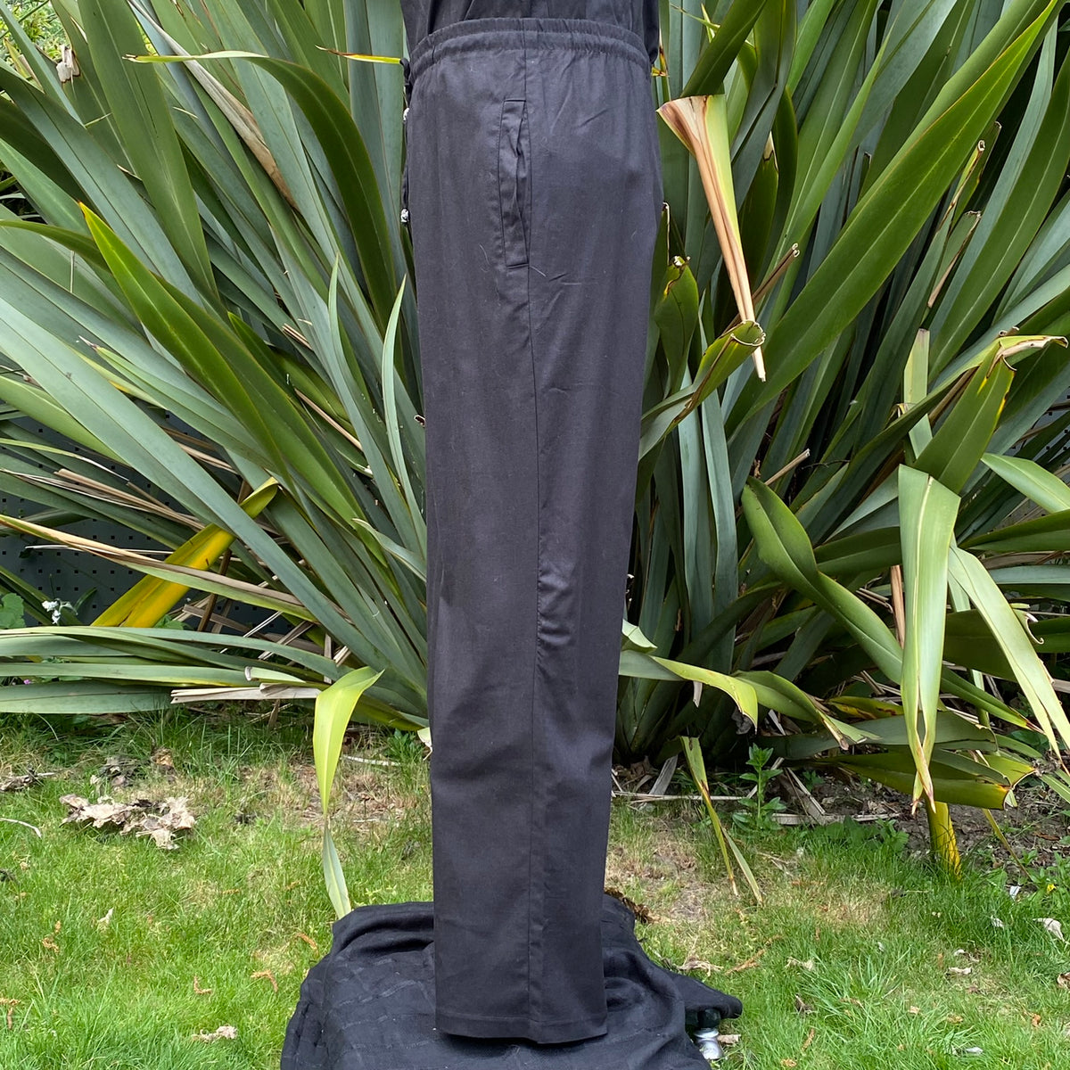 black cotton fantasy pants with straight silhouette.