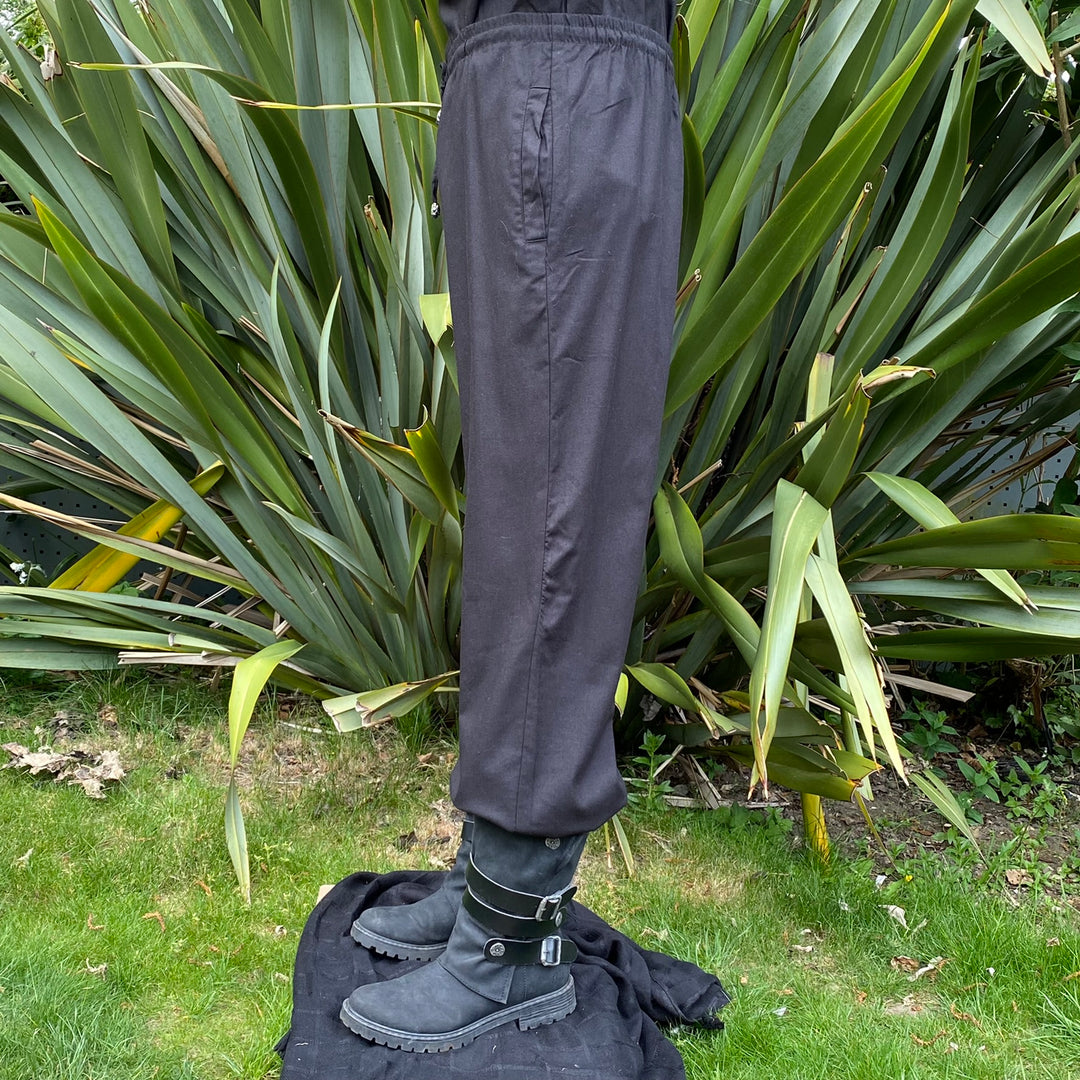 straight-leg medieval trousers in black cotton fabric.