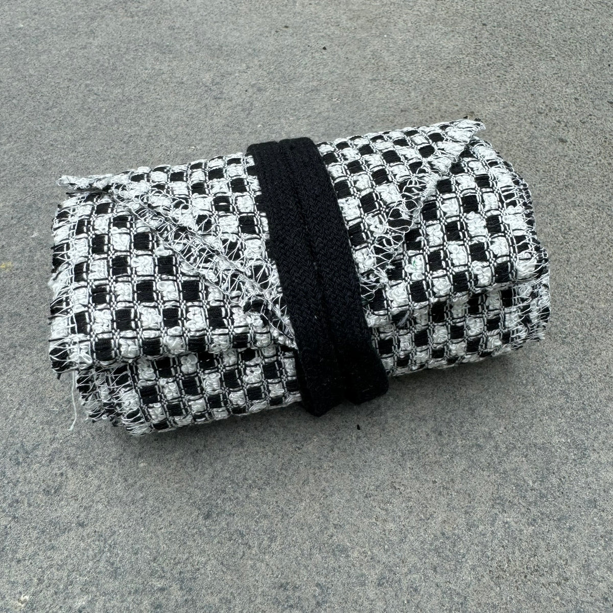 Black and white checkered wool leg wraps for medieval LARP, folded neatly.