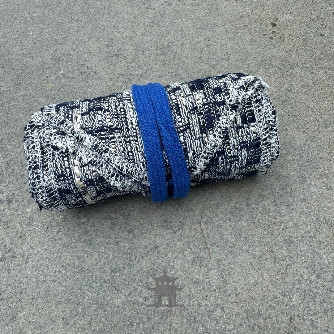 Blue and white knitted wool leg wraps rolled up for LARP or medieval wear.