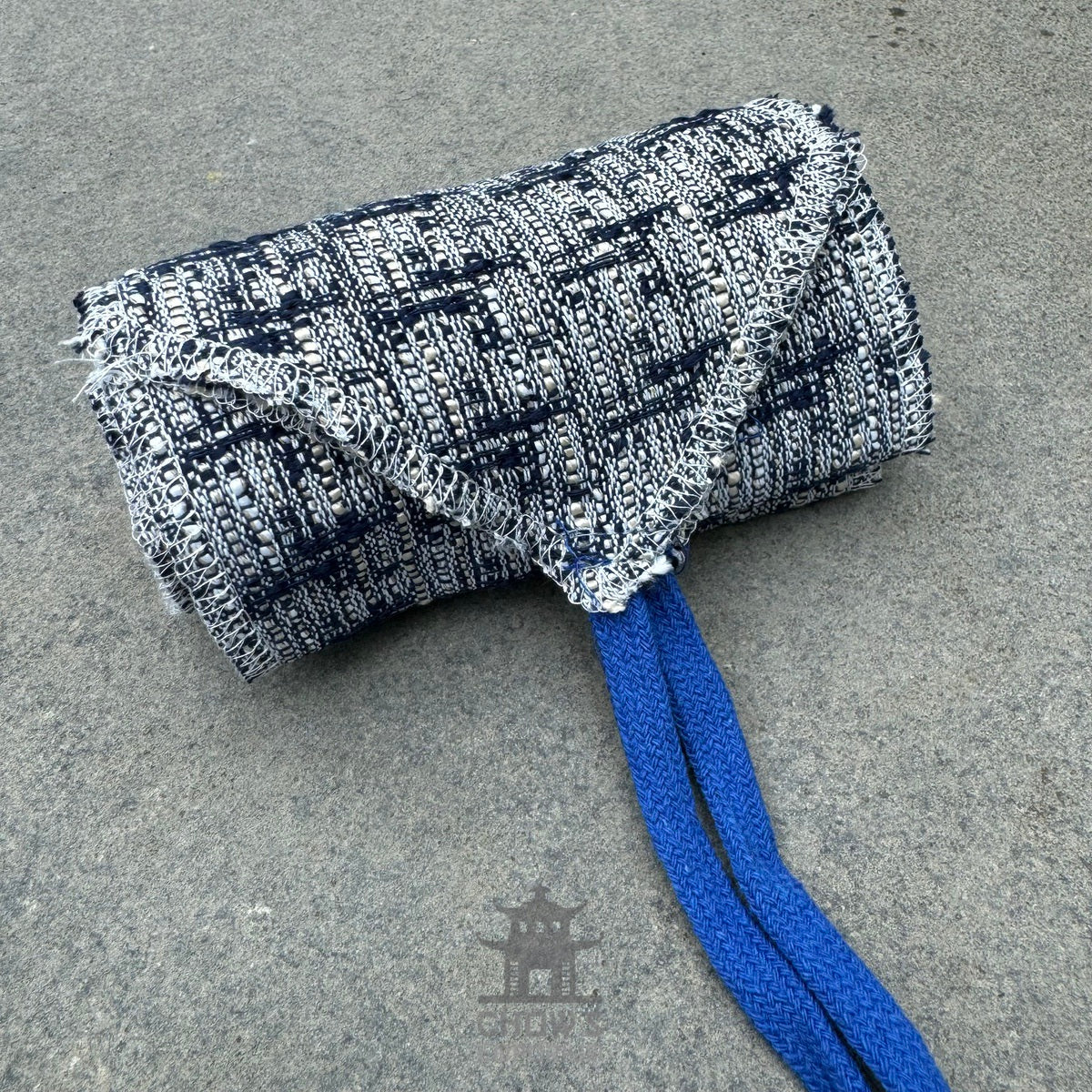 Blue and white knitted wool leg wraps for LARP, rolled with blue ties.