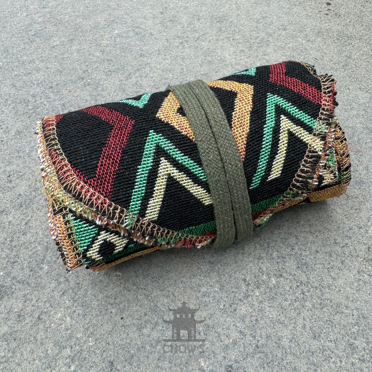 Folded green Aztec pattern pirate sash for LARP, textile fabric, side view.